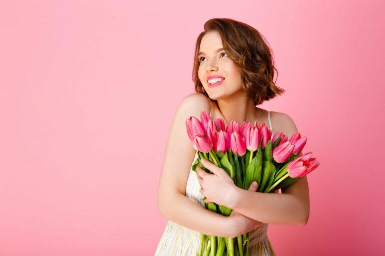 cheerful-woman-with-bouquet-of-pink-tulips-looking-away-isolated-on-pink.jpg